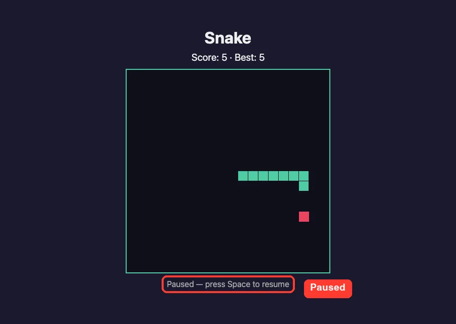 The Snake game paused with the hint line reading Paused, press Space to resume